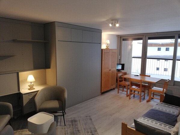 A compact living space with a kitchenette, a dining area, and a sofa. - Ski-In Studio with Parking in Courchevel (Courchevel 1650)