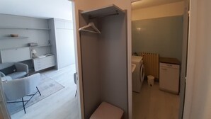 Eine moderne Wohnung mit Wohnbereich, einer kleinen Küchenzeile und einem Badezimmer.