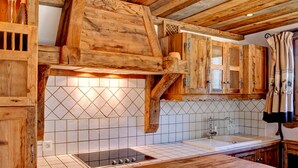 A rustic kitchen with wooden cabinets, a tiled backsplash, and a wooden countertop. - Charming apartment in Courchevel 1650 with parking (Courchevel 1650)