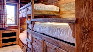 A wooden bunk bed with multiple levels, a window with curtains, and a tiled floor. - Charming apartment in Courchevel 1650 with parking (Courchevel 1650)