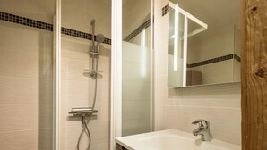 A bathroom with a shower, a sink, and a mirror. - 3* Apartment, sleeps 6, pets allowed, garage, mountain view (La Clusaz)