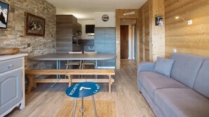 A modern interior with a dining area, kitchen, and a sofa. - 3* Apartment, sleeps 6, pets allowed, garage, mountain view (La Clusaz)