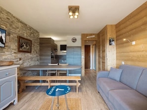 A modern interior with a dining area, kitchen, and a sofa. - 3* Apartment, sleeps 6, pets allowed, garage, mountain view (La Clusaz)