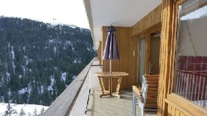 Un balcone in legno con vista su montagne innevate.