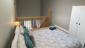 A bedroom with a bed, a nightstand, a lamp, a wardrobe, and a skylight. - Pretty Properties - 30 Chaldron Court (Darlington)