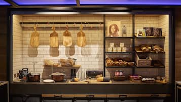 Una cocina con tablas de cortar de madera colgadas, una exhibición de pan y varios electrodomésticos.