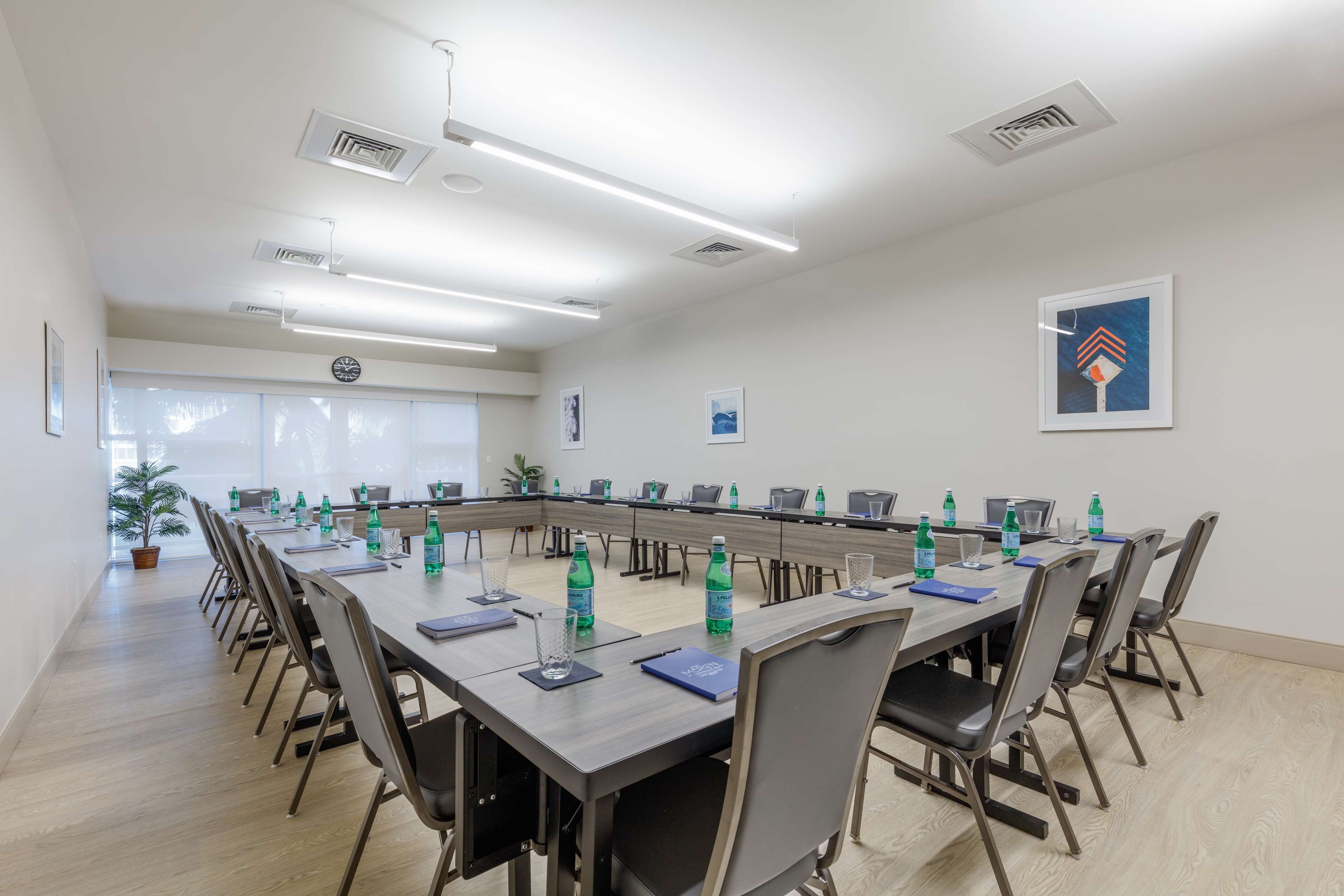 A conference room with a long table, chairs, and water bottles.