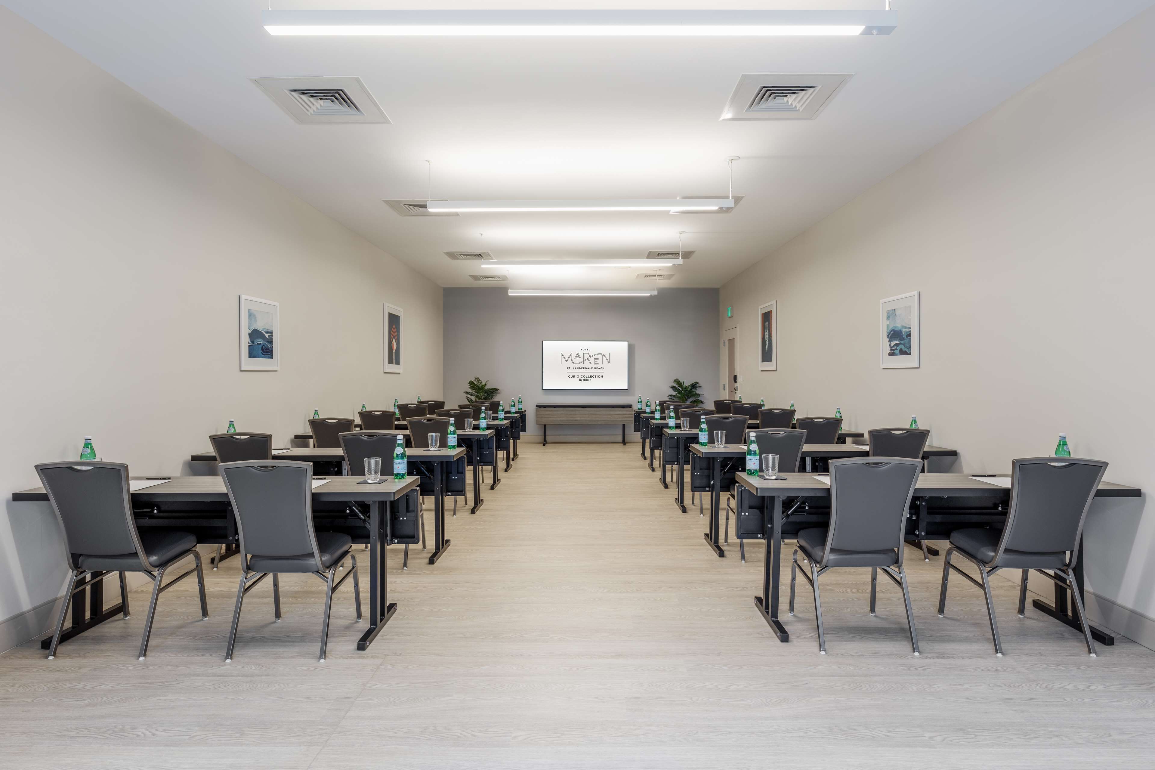 Une salle de conférence équipée de tables et de chaises disposées pour les réunions.