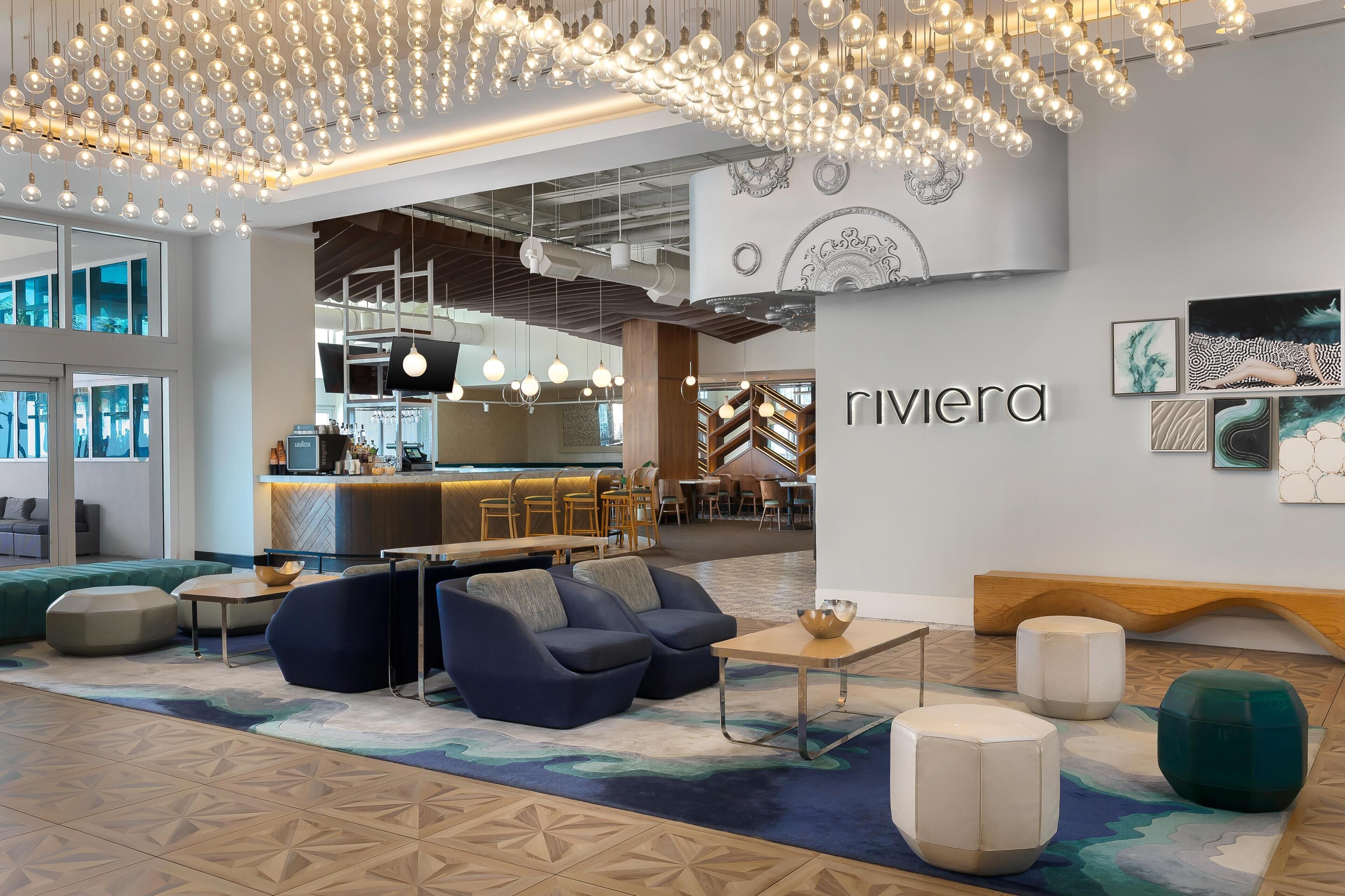A modern interior with seating, a bar area, and a wall with the name 'Rivera'.
