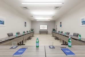 Une salle de conférence équipée d’une longue table, de chaises, de bouteilles d’eau et d’un écran de projection sur lequel est affiché le titre « The MAREN ».