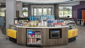 Een modern drank- en snackautomaat met diverse drankjes en snacks, een gekoeld gedeelte en een digitaal betaalapparaat.