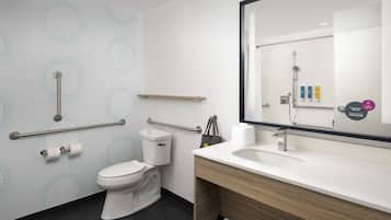 Un baño moderno con inodoro, lavamanos y espejo.