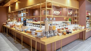 A buffet setup with various food items and condiments. - INNSiDE by Meliá Milano Torre Galfa (Milan)