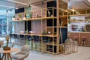 A modern bar area with wooden shelves, bar stools, and decorative lanterns.