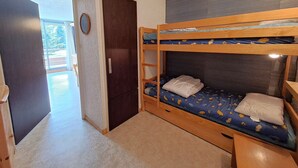 Una habitación con literas, una puerta y vistas a un balcón.
