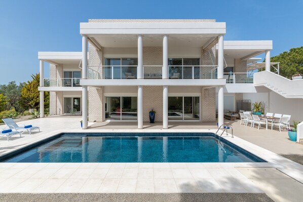 Een seizoensgebonden buitenzwembad, parasols voor strand/zwembad