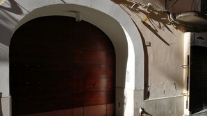 A large wooden door with a white archway, a small window, and a doorbell. - B&B Ninfa (Caserta)