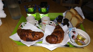 A tray with two croissants, a plate of bread, and a Nutella container on a table. - B&B Ninfa (Caserta)