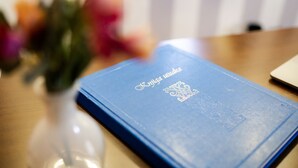 Een blauw boek met opdruk op een houten ondergrond.
