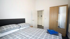 Une chambre à coucher comprenant un lit, une armoire et une porte donnant sur une salle de bain.