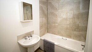 Une salle de bain avec un lavabo, un miroir et une douche.