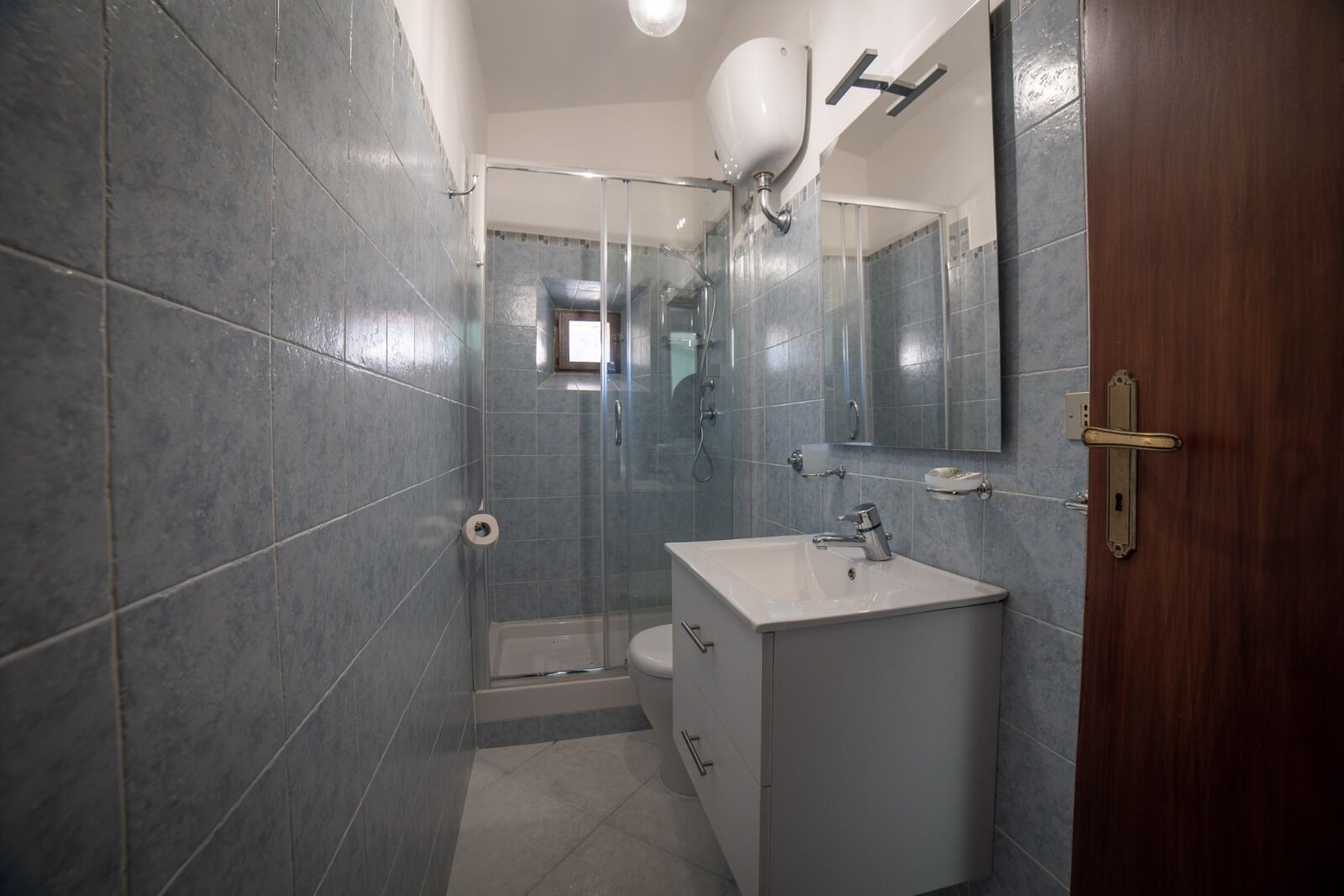 A bathroom with a shower, toilet, and sink.