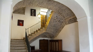 A staircase with stone walls and a wooden door at the top.