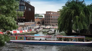 Ein Kanal mit einem Boot, Gebäuden und Bäumen.