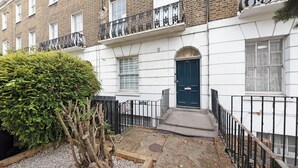 A townhouse with a dark blue front door, white brick exterior, and a small front garden. - Camden Street NW1 - 🚇 Camden Town 🚇 Camden Road (London)
