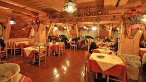 Een rustieke eetruimte met houten wanden en tafels, met traditionele decoratie en een warme sfeer.