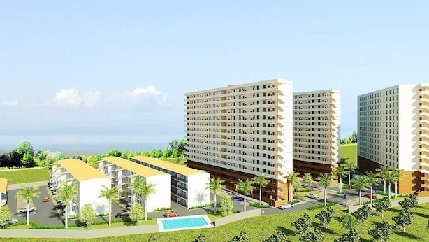 Un moderno complejo residencial con varios edificios altos, una piscina y una zona verde bien cuidada.