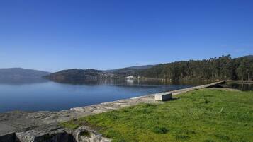 Un lago tranquilo con un muro de hormigón y un edificio pequeño en la orilla opuesta.