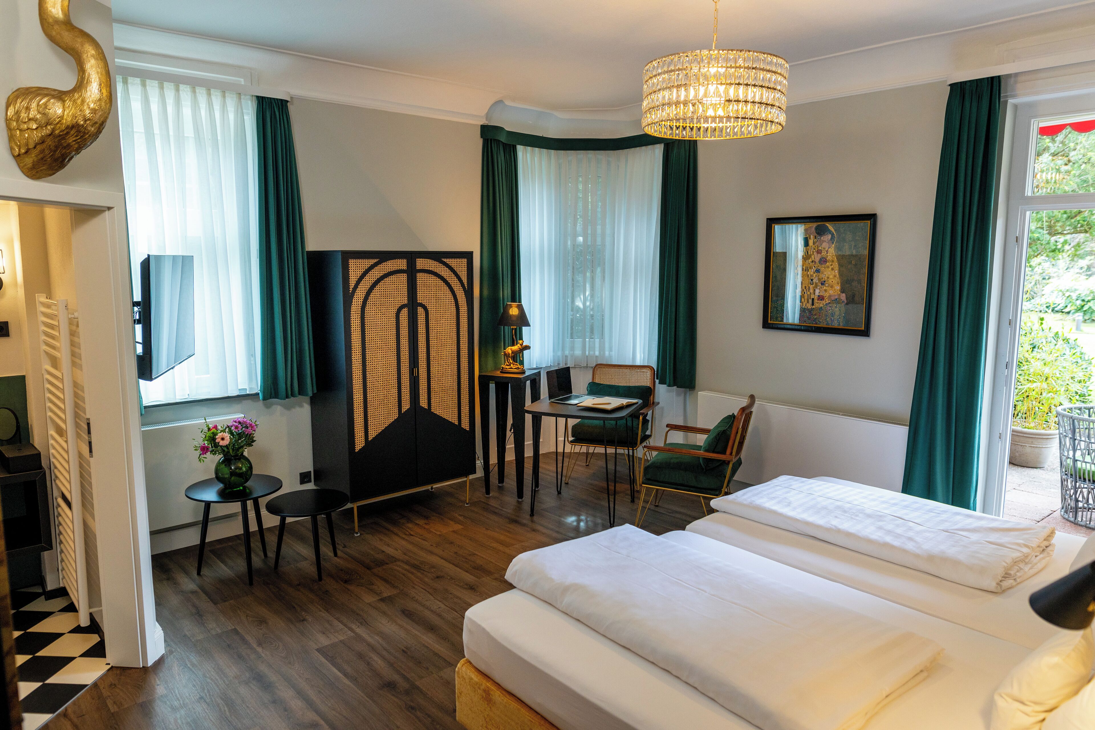 A hotel room with a bed, a desk, a chair, a small table, and a decorative item on the wall.