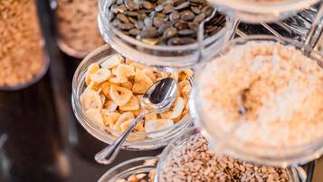A variety of food items in glass containers, including nuts, seeds, and dried fruits.