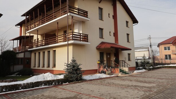 A two-story building with a balcony on the upper floor. - Pensiunea Maria (Floresti)