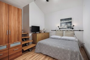 A bedroom with a bed, a TV, a painting, and a wardrobe. - Villa with pool and private waterfront (Jablanac)
