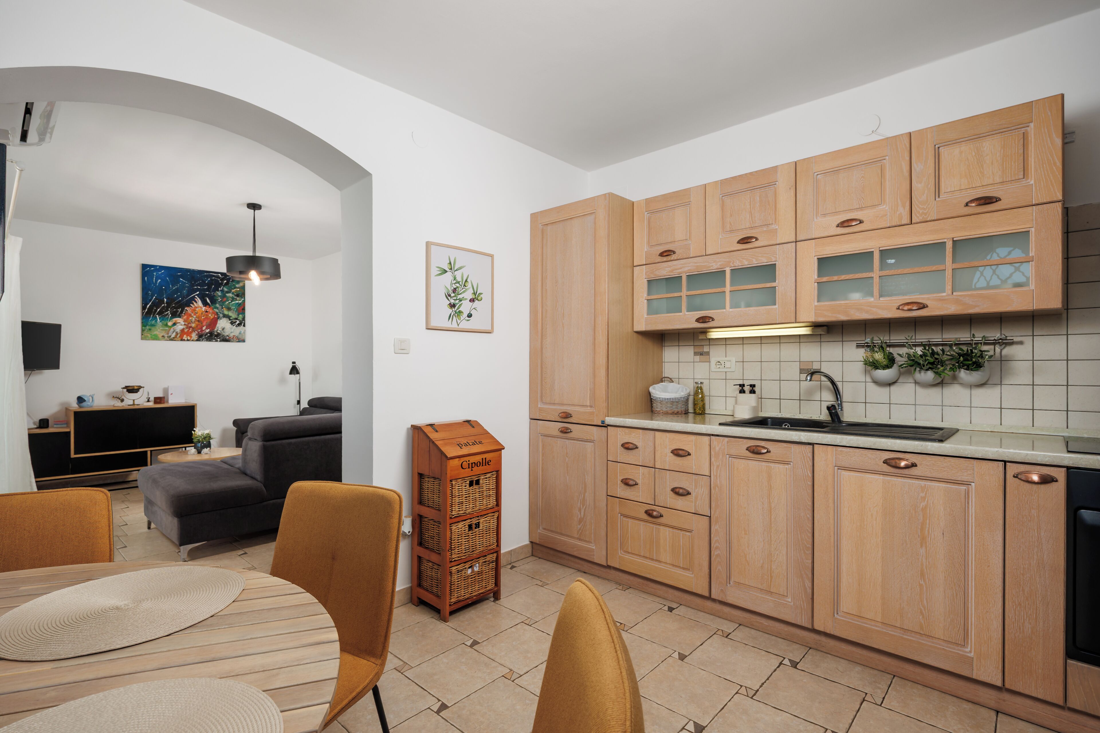 Une cuisine moderne avec des meubles en bois, un four encastré et un évier.