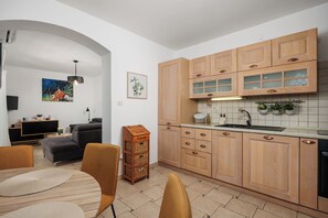 A modern kitchen with wooden cabinets, a built-in oven, and a sink. - Villa with pool and private waterfront (Jablanac)