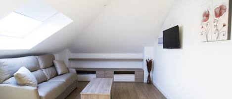 A modern living room with a sofa, a coffee table, and a built-in bench with storage.