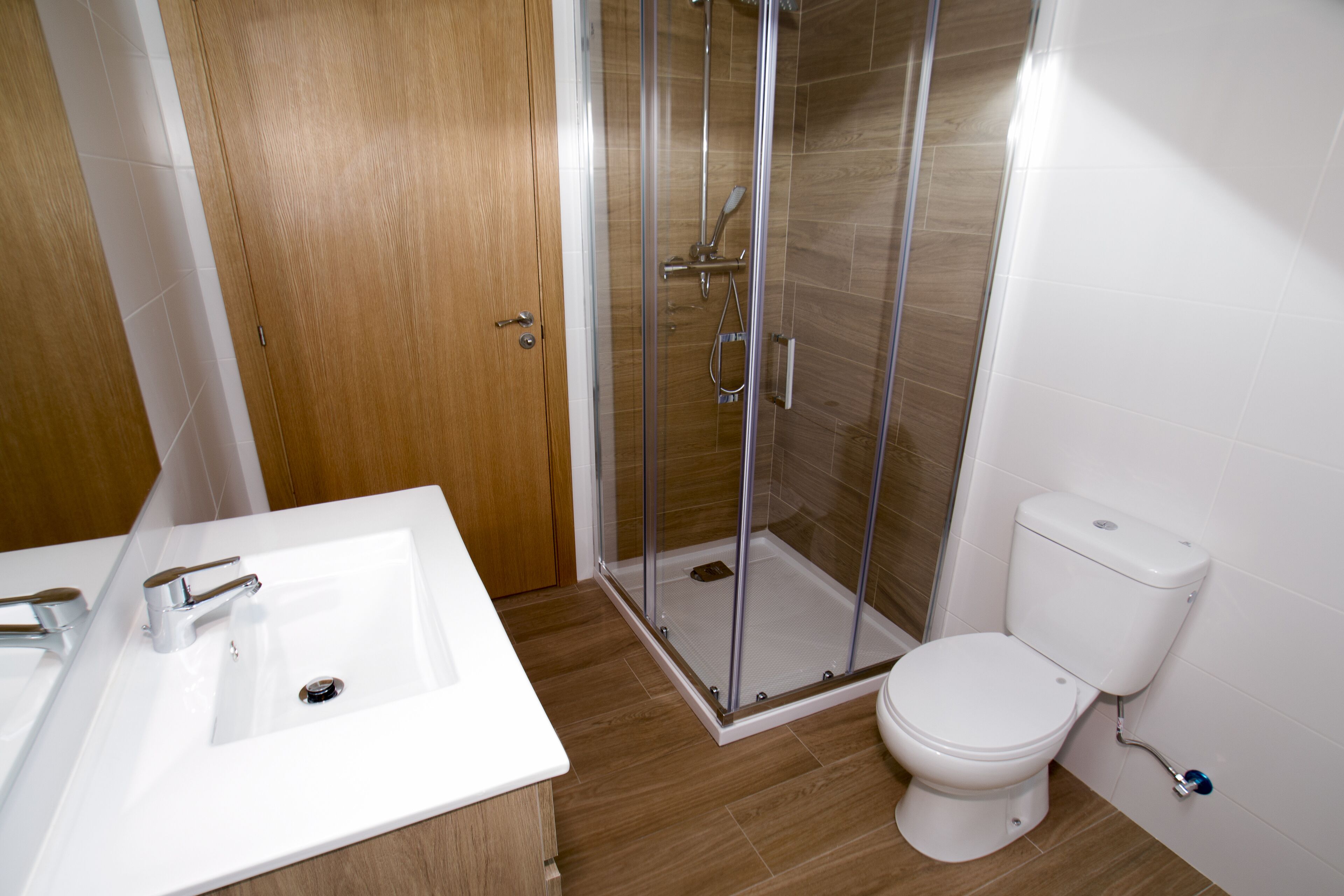A bathroom with a shower, toilet, and sink.