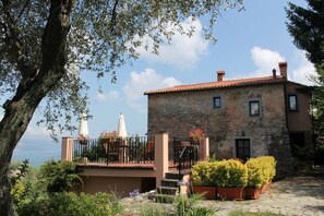 A stone building with a balcony, potted plants, and a view of the sea. - Three-room apartment with breathtaking view 10 minutes from the 5 Terre, free Wi (La Spezia)