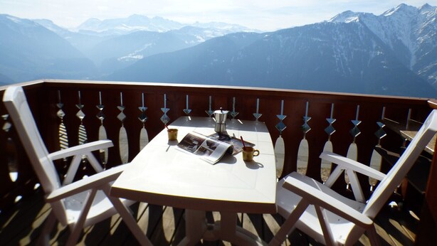 A table with a newspaper, a cup, and a spoon on a balcony overlooking snow-capped mountains. - APARTMENT AT THE FOOT OF THE SLOPES (Villard-sur-Doron)