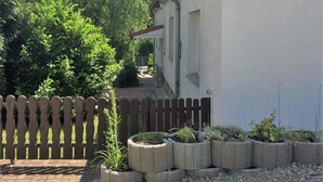 Una zona residencial con un edificio blanco, una valla de madera y un camino de grava.