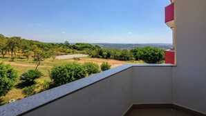 A balcony with a clear view of a green landscape, including trees and a distant view of a city. - OYO Tropical Confort Hotel, Brasilia (São Sebastião)