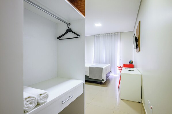 A hotel room with a bed, a small desk, a chair, and a wardrobe. - OYO Tropical Confort Hotel, Brasilia (São Sebastião)