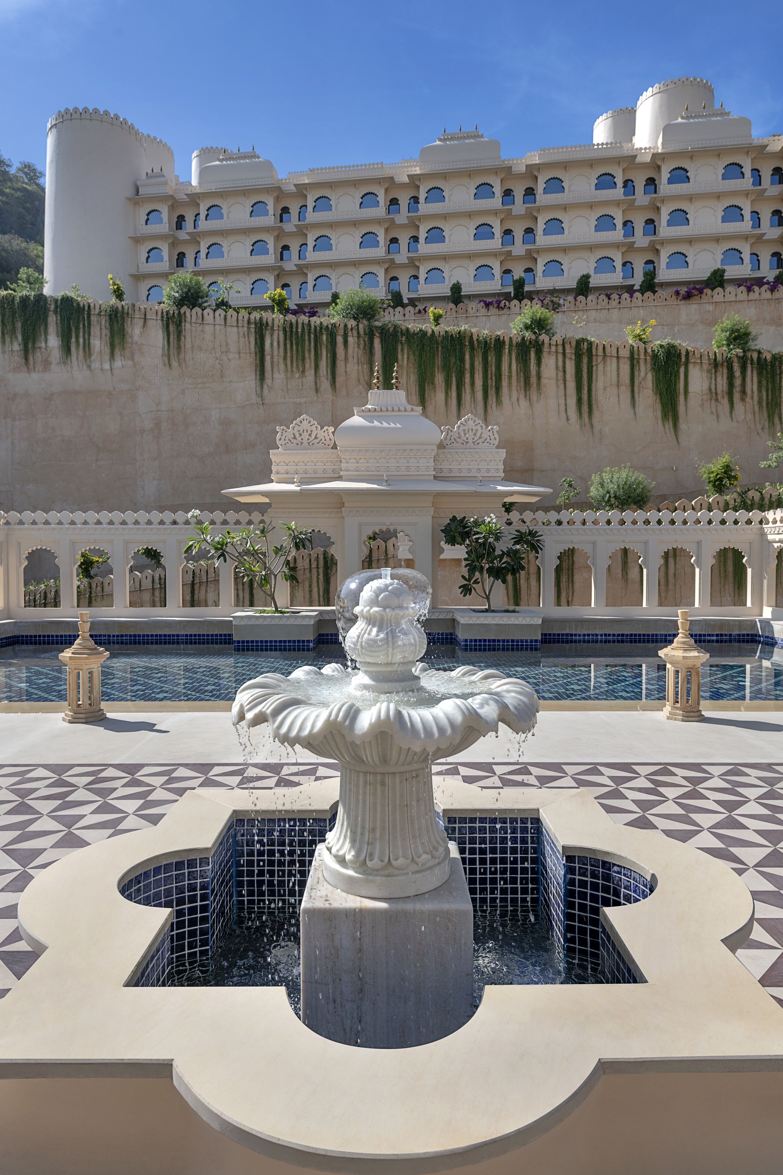A large, multi-story building with a pool and a central fountain.