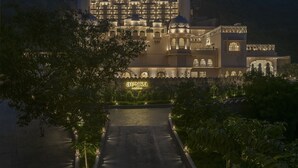 A large, illuminated hotel with a grand entrance, multiple balconies, and a prominent sign reading "Aurika." - Aurika, Udaipur - Luxury by Lemon Tree Hotels (Udaipur)