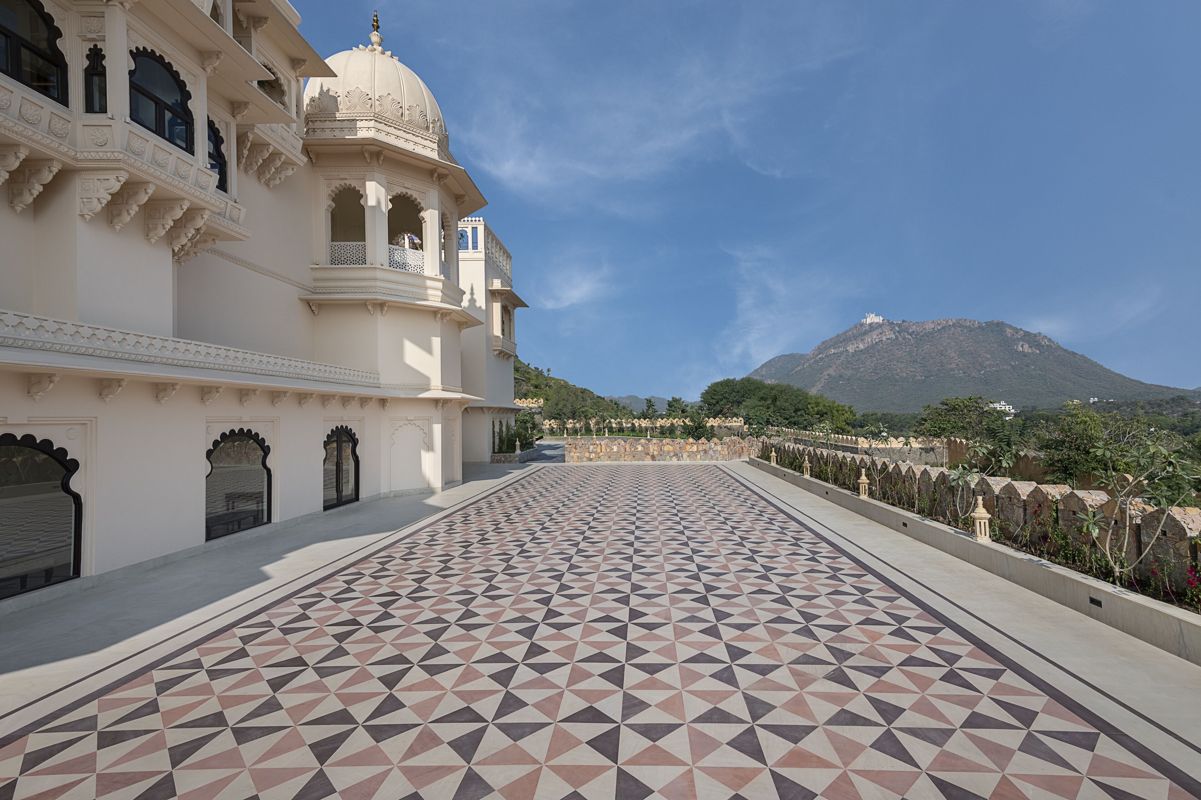 A large, white building with intricate architectural details and a patterned tiled floor.