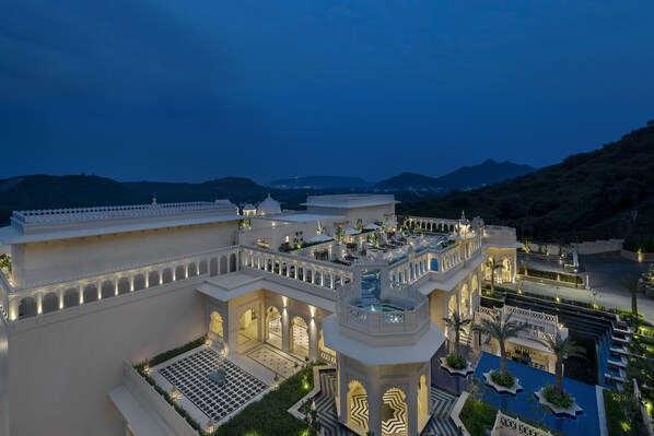 A large, multi-story hotel with a central courtyard, multiple balconies, and a pool area. - Aurika, Udaipur - Luxury by Lemon Tree Hotels (Udaipur)