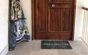 Una puerta de madera con un felpudo que dice 'WELCOME'.
